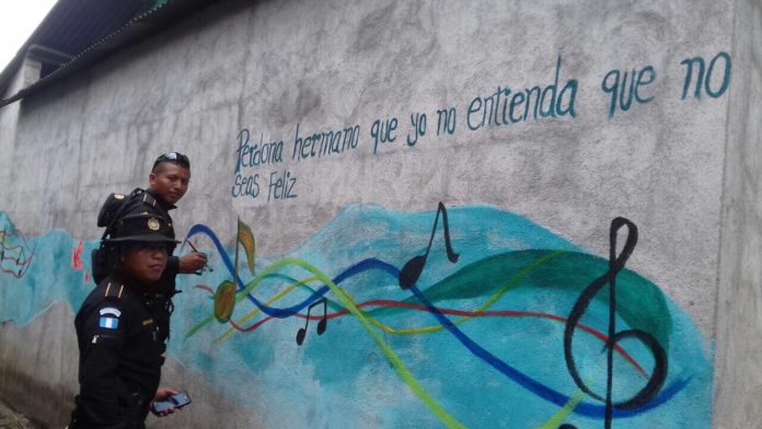 Agentes policiales borran grafitis en Cuyotenango